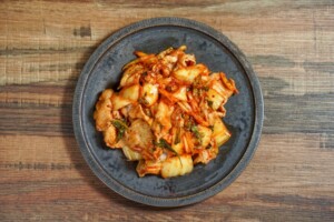 ポンポコ団キングの「スペシャル豚キムチ」 ①玉ねぎ 1 2個 をスライス、ネギ 2掴み を輪切りに、ニラ 適量 をざく切りにする ②豚バラ 250g とスライスした玉ねぎを炒める③キムチ 150g を入れ炒める。 ④切ったニラとネギを入れて炒め、小エビ ２つまみ