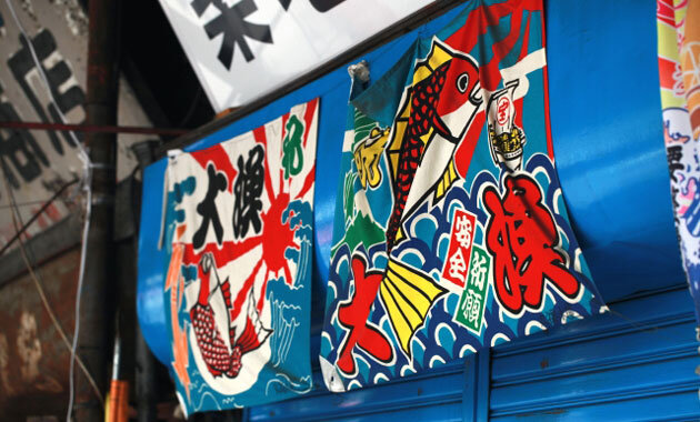 大漁旗はためく玄界島 大漁祈願祭の日には各漁船に美しい大漁旗が掲げられました。 色とりどりの旗がはためく姿はとても迫力があり、いつまでも見入ってしまいます。大漁旗の絵柄は、「縁起が良い」といった意味を持つものが多く、豪華で色彩の鮮やかなデザインが特徴