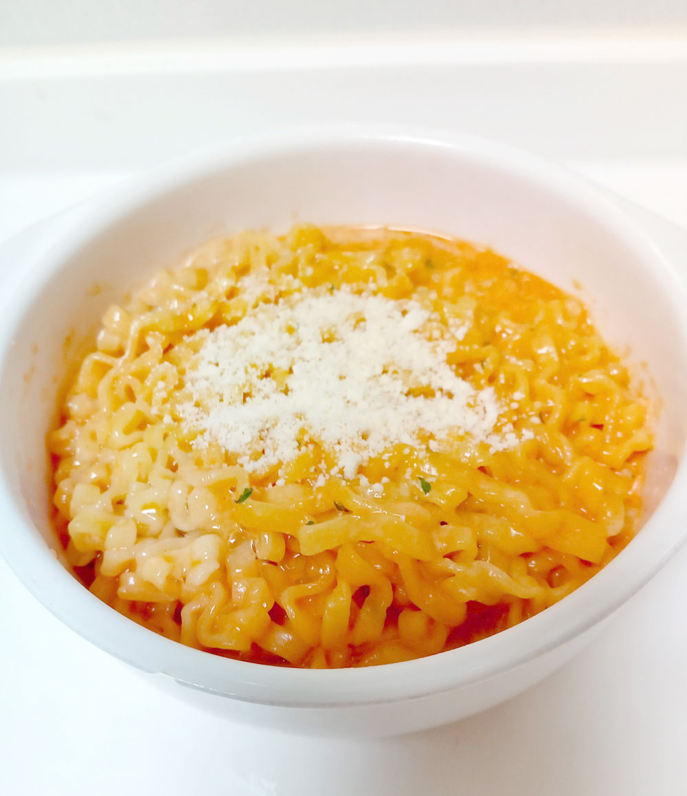 ブルダック風カルボうどん ,材料1人前 , うどん:1玉, ソーセージ:3本, コチュジャン:大さじ1と1 2, 粉チーズ:小さじ2,鶏がらスープの素:小さじ1, 卵黄:1ヶ, 牛乳:大さじ1, 万能ネギ:適量, 追い粉チーズ:適量, 韓国でも日本でも人気の「プルダック麺」。,もちっとしたうどんと辛すぎなくて食べやすい。, パッと作れて深夜メシにも最高だ。,